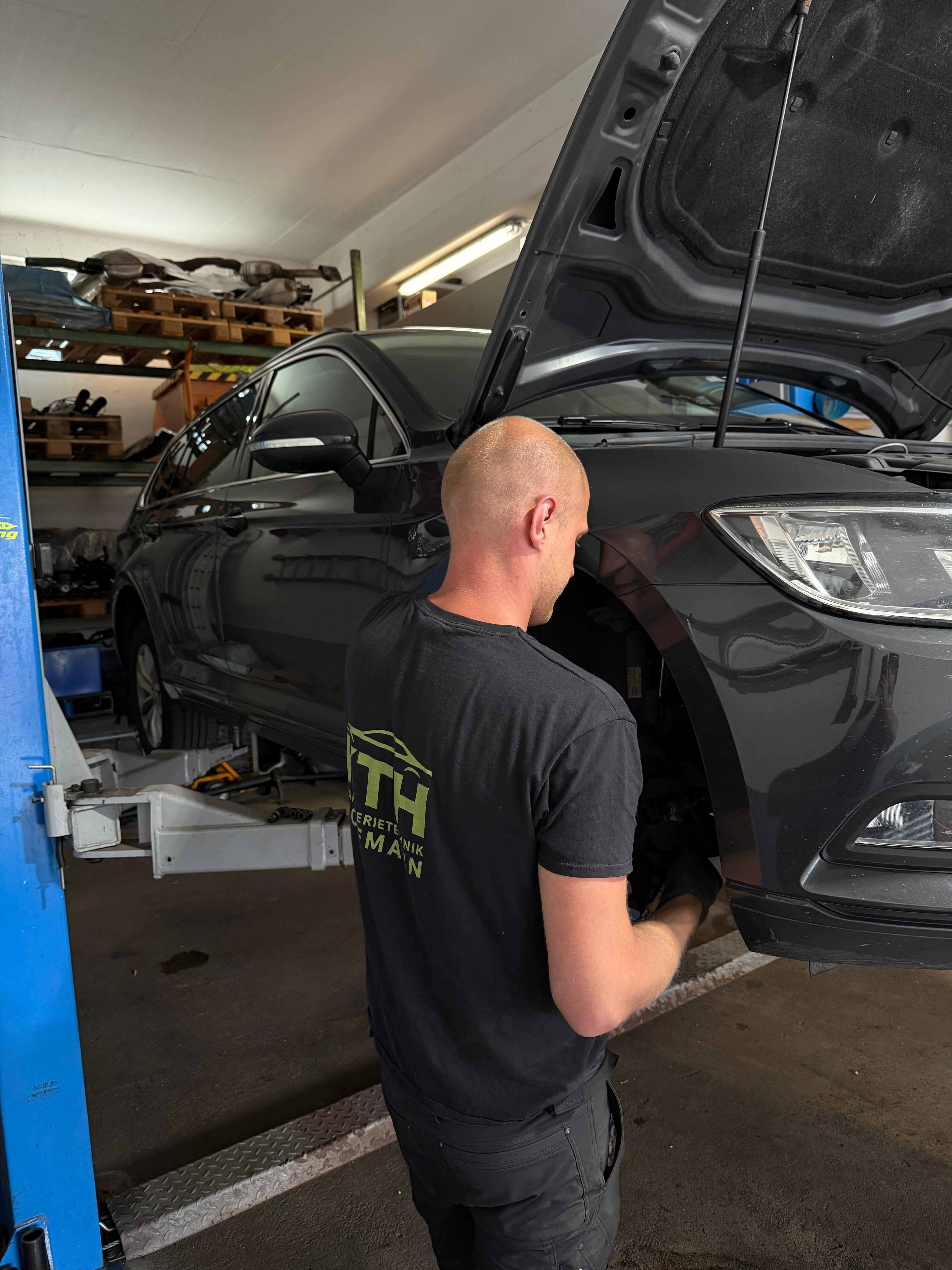 KFZ-Mechaniker im KTH T-Shirt bei der Arbeit · Karosserietechnik Hoffmann